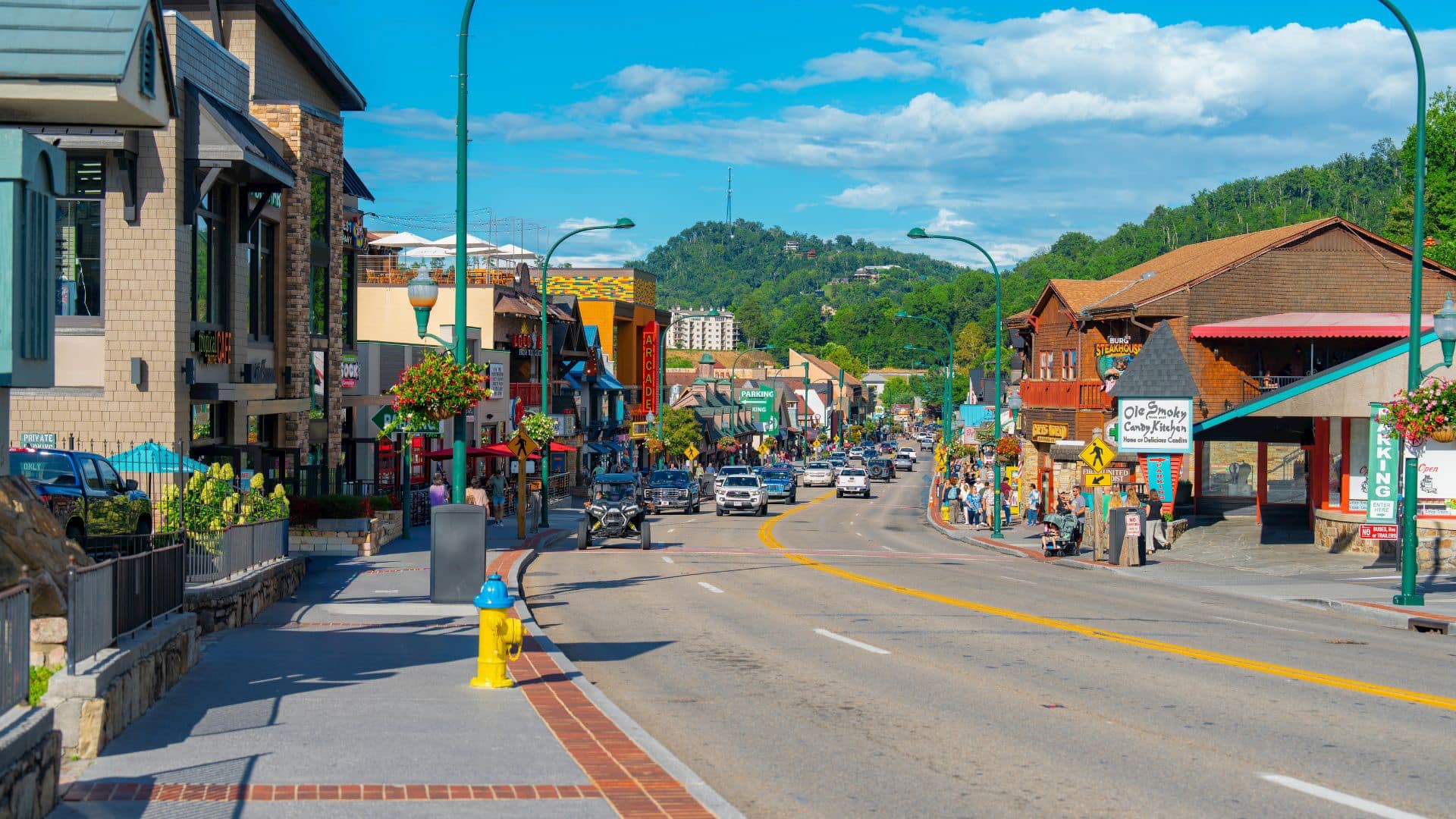 An evening view of Main Street in Gatlinburg, with lights and buildings visible.